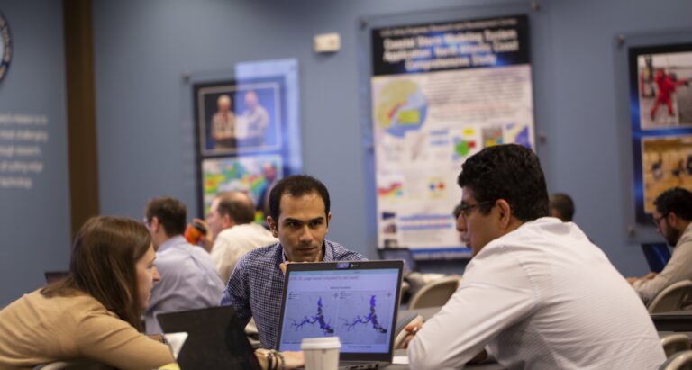 Attendees of the 2019 ADCIRC Users Group Meeting discuss computer models in between presentations. Photo by Chris A. Johns.